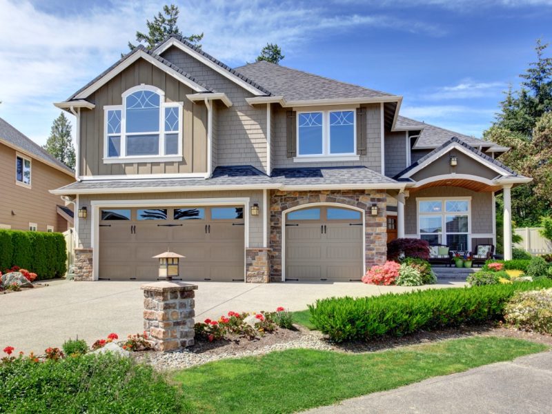 Home exterior with garage and driveway with nice landscaping desing around