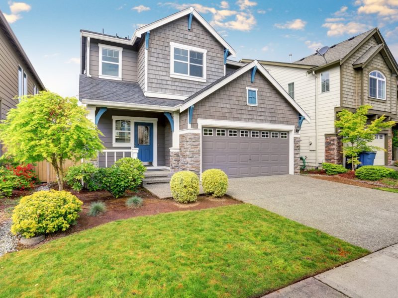 Nice curb appeal of two level house, mocha exterior paint and concrete driveway. View of cozy small porch