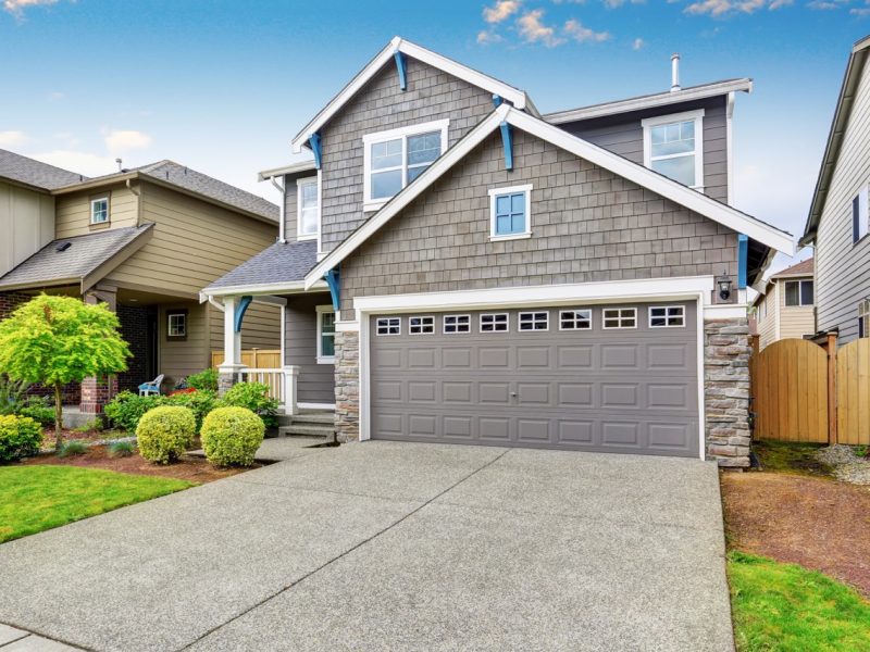 Nice curb appeal of two level house, mocha exterior paint and concrete driveway. View of cozy small porch