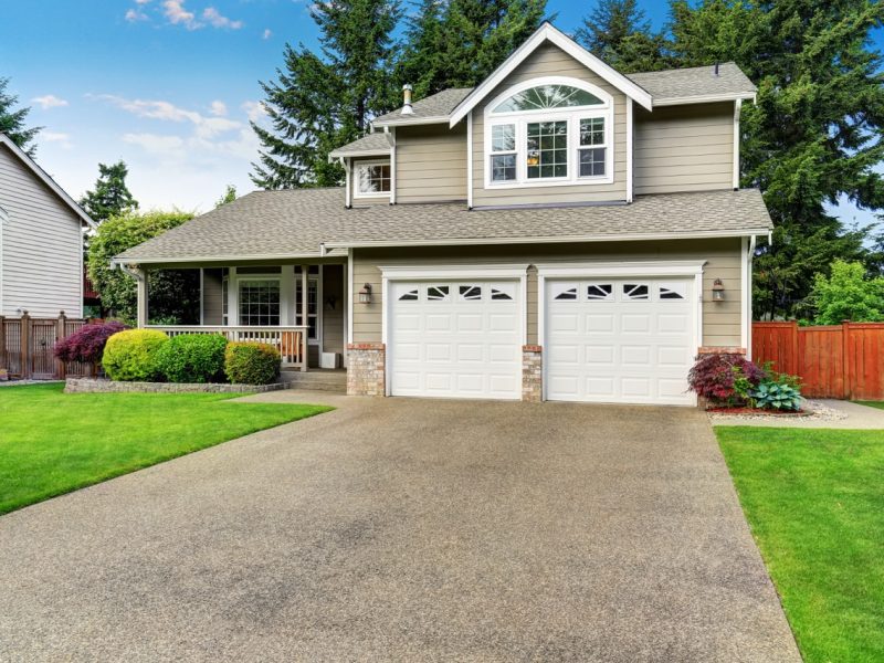 Curb appeal. American house exterior with double garage, concrete floor porch and well kept lawn. Northwest, USA
